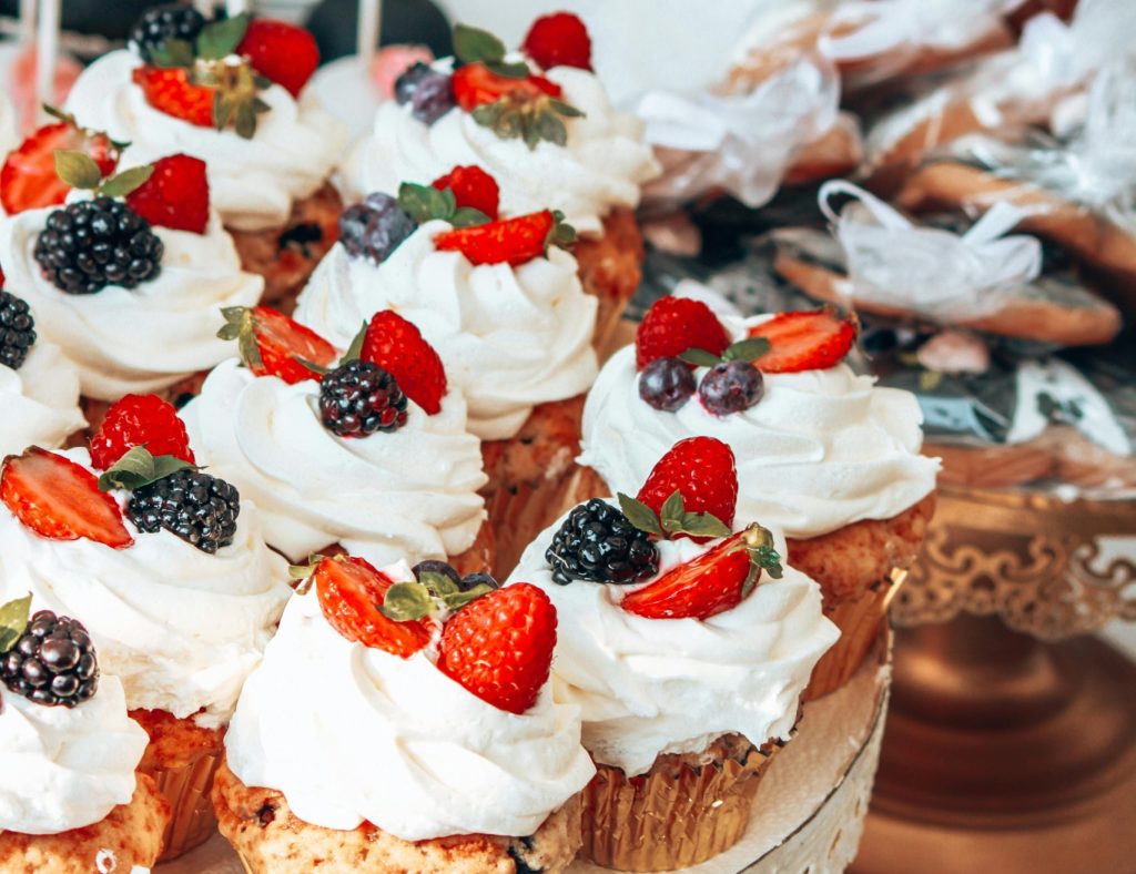 A tempting display of beautifully decorated cupcakes with fresh berries on a stand.